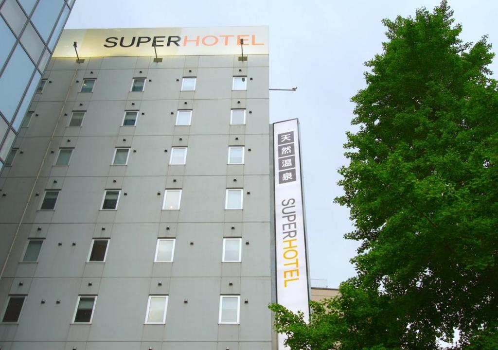 a building with a sign for a hotel at Super Hotel Sendai Hirose Dori in Sendai