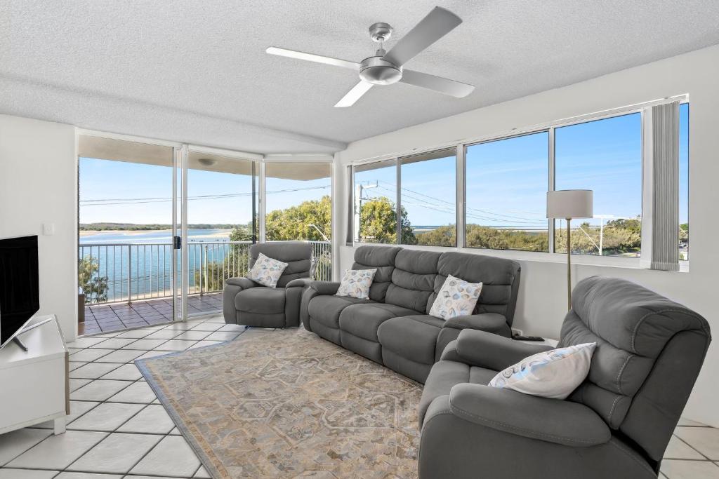 a living room with couches and a ceiling fan at Seascape U7 in Golden Beach
