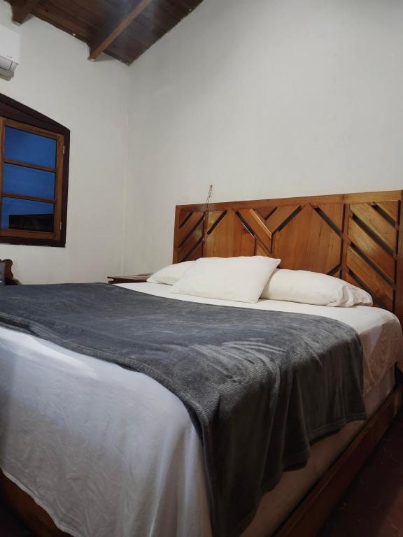 a bedroom with a large bed with a wooden headboard at Casa Legranite Bay in Trujillo