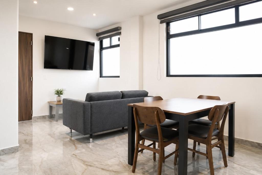 a living room with a table and a couch at Loft Ejecutivo San Martin Centro Wifi Tv 65 in San Martín Texmelucan de Labastida