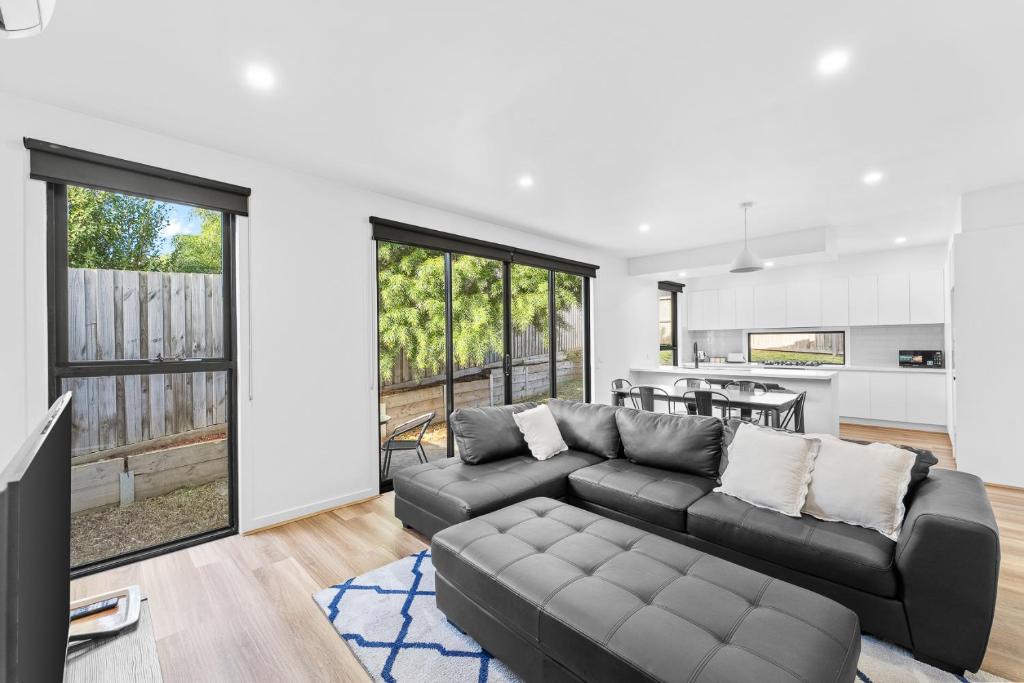 a living room with a couch and a kitchen at Sleek Contemporary Haven Geelong in Highton