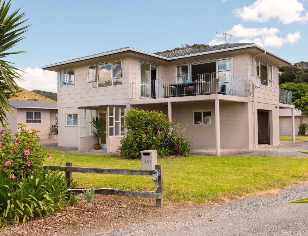 a house with a fence in front of it at Waitangi Beach House in Paihia