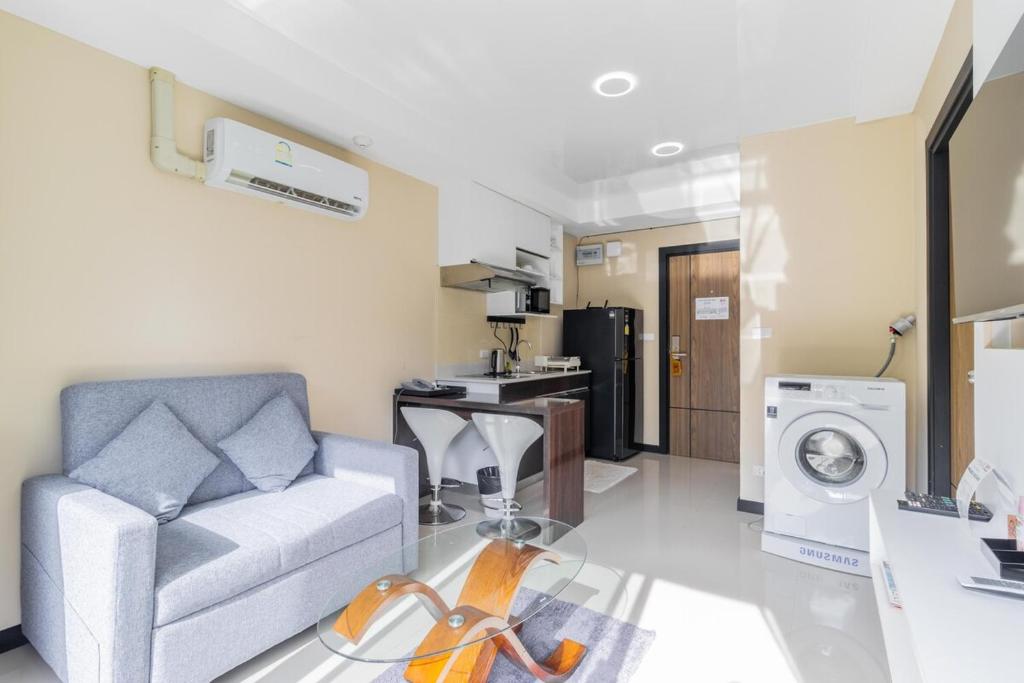 a living room with a couch and a washing machine at Beachside 1BR Condo Pool Gym Phuket- MBC C172 in Ban Bo Sai Klang