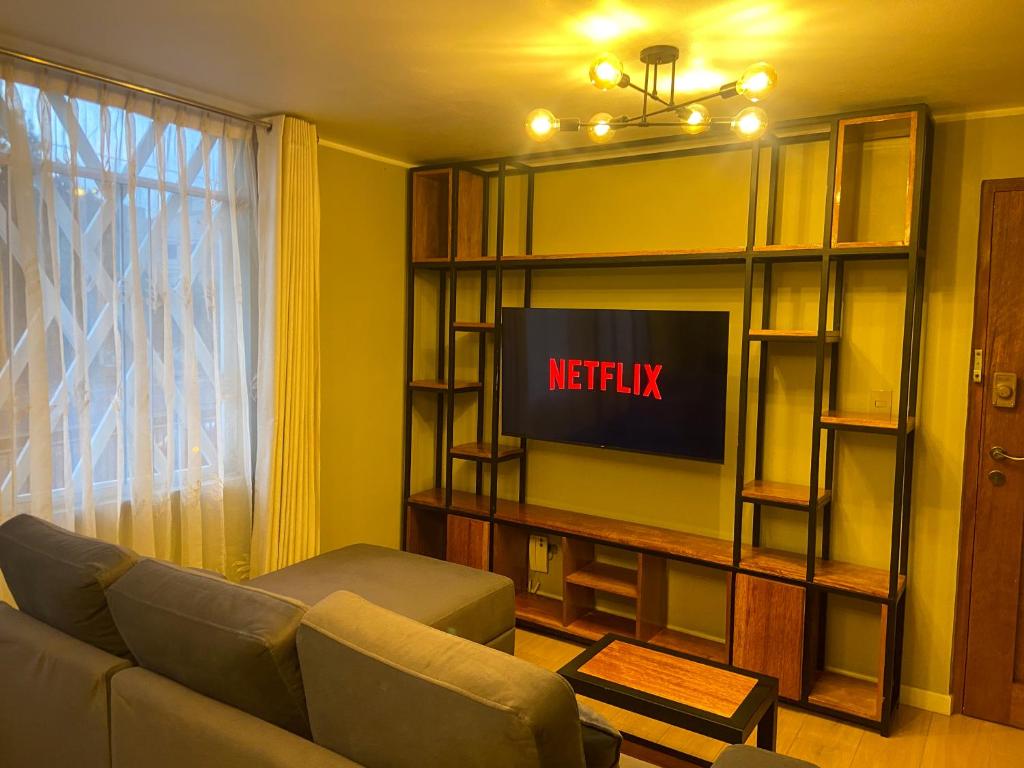 a living room with a couch and a television at Refugio Nordico de 3 habitaciones inc Cochera en 2do piso in Trujillo