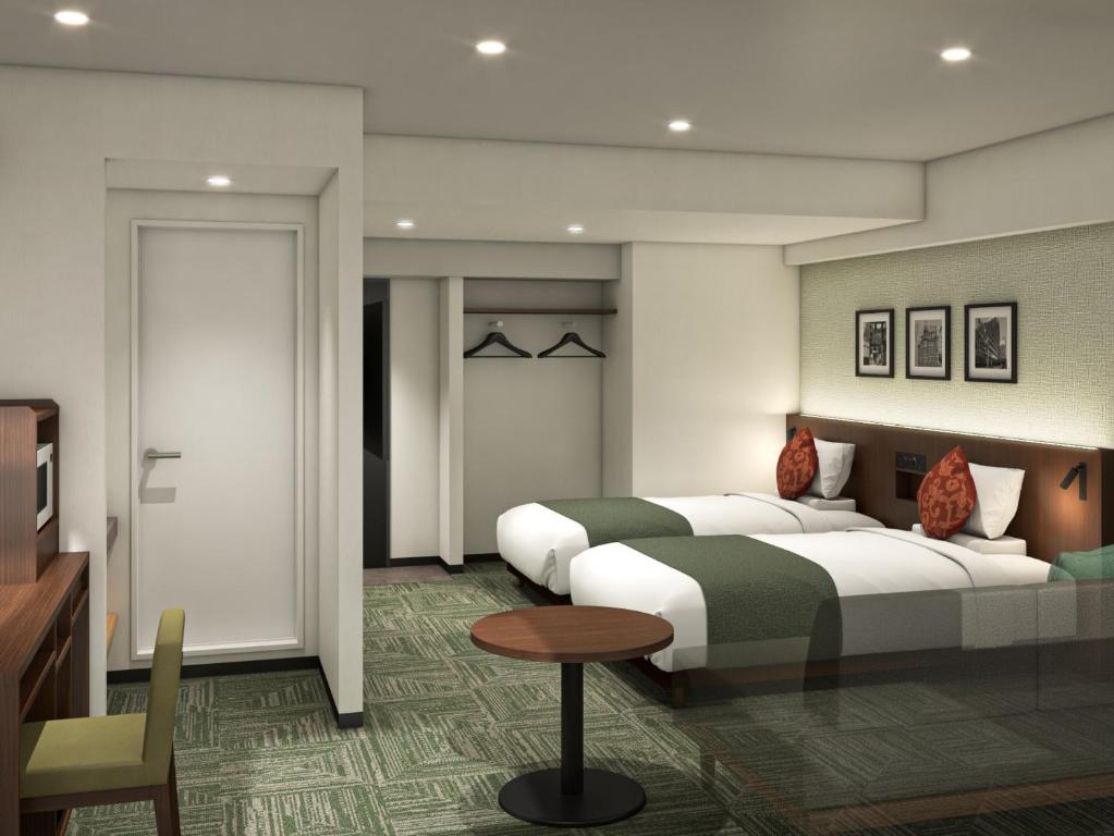 a hotel room with two beds and a table at HOTEL MYSTAYS Asakusa in Tokyo