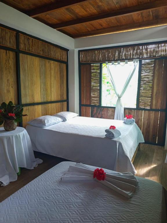 a bedroom with two beds and a window at Posada Nore, Nuquí in Arusí