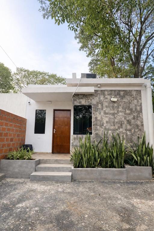 a house with a brown door and some plants at Casa completa Ecovia Ruta Luque San Bernardino in Zarate Isla
