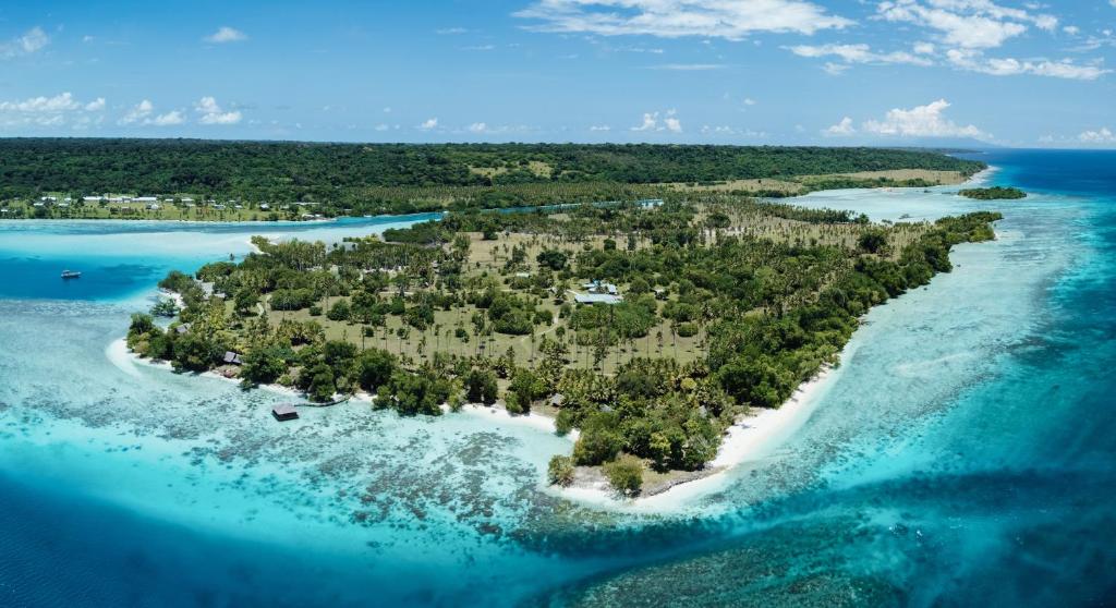 an island in the ocean next to the water at Ratua Private Island Resort in Aimbuei Bay