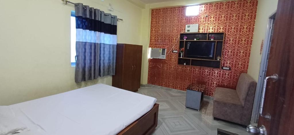 a small room with a bed and a tv on a wall at Hotel relaxinn in Saharsa