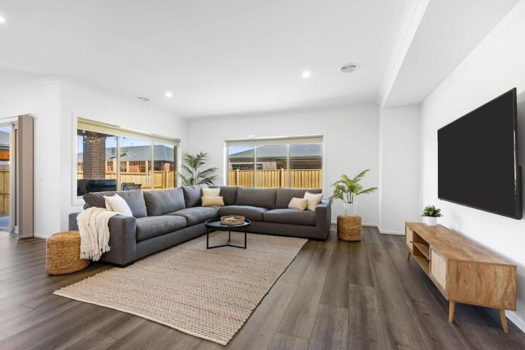 a living room with a couch and a flat screen tv at City & Surf Getaway in Grovedale