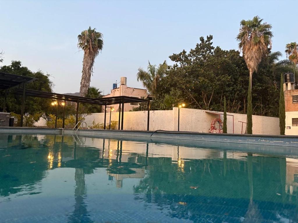 an empty swimming pool with palm trees in the background at Ribera del Lago in Jocotepec