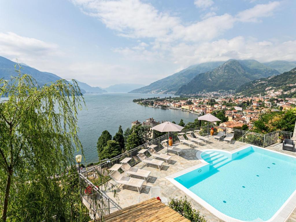 a swimming pool with chairs and a view of the water at Wonderful flat with swimming pool, lift and garden in Gravedona