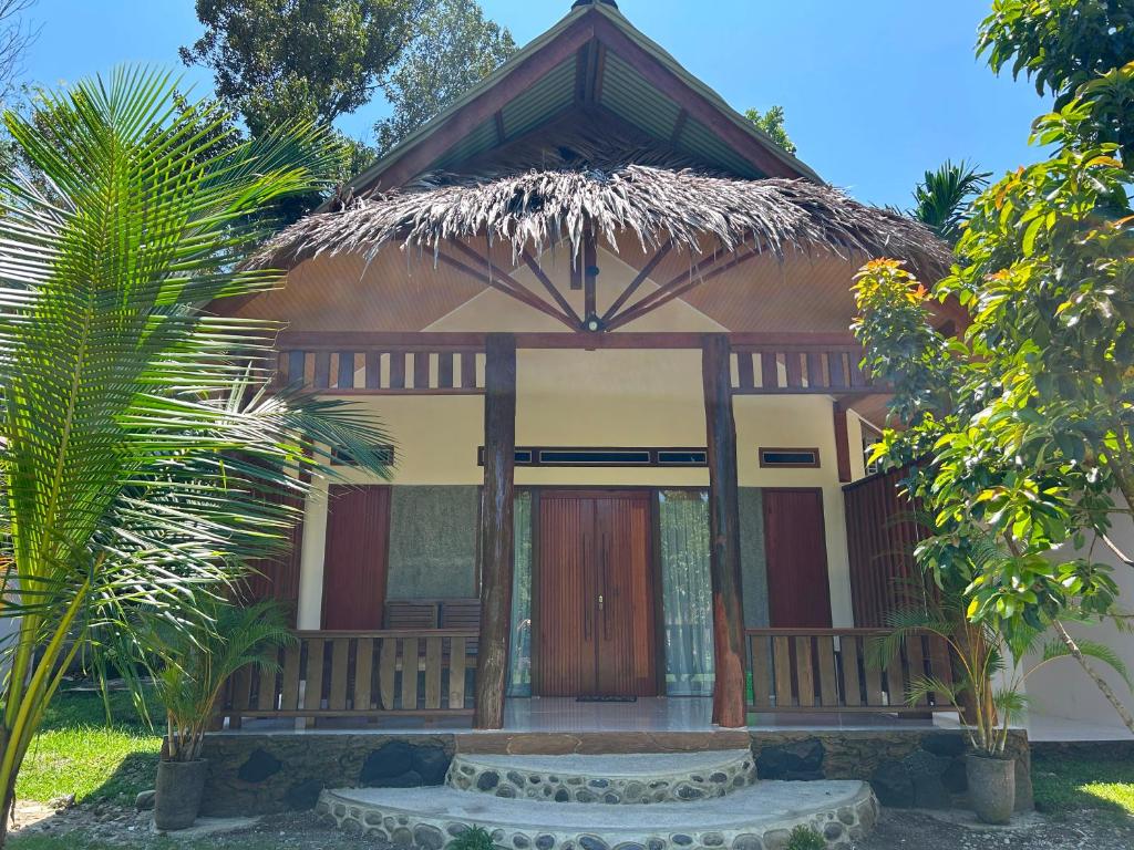 a small house with a thatched roof at Leuser Inn & Jungle Trekking in Bukit Lawang