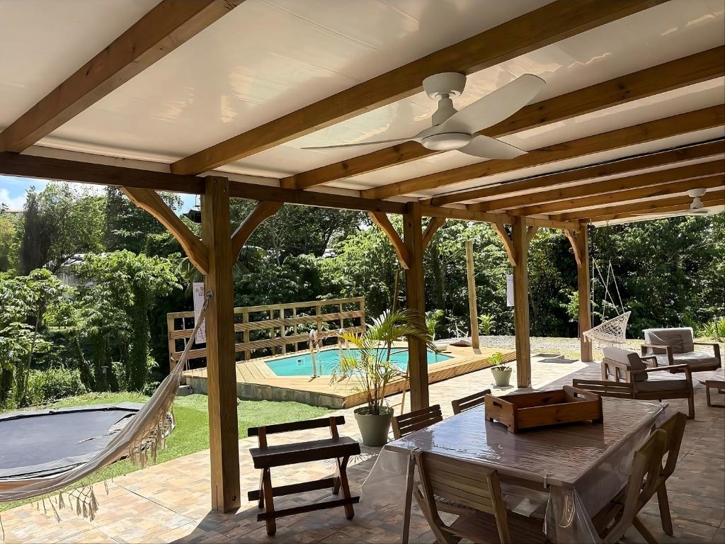 a pavilion with a table and chairs and a hammock at Évasion Caraïbes in Ducos