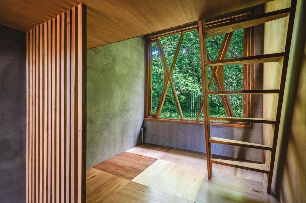 a room with a large window and a wooden floor at Bunagaya in Ujimi
