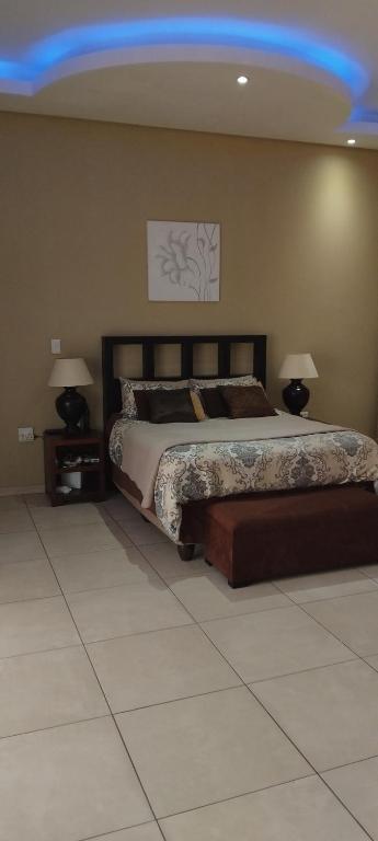 a bedroom with a large bed and two lamps at RestZone Healing Guest Suite in Pietermaritzburg