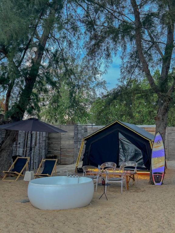 a tent and chairs and a bath tub in the sand at Coody Seastar in Ban U Taphao