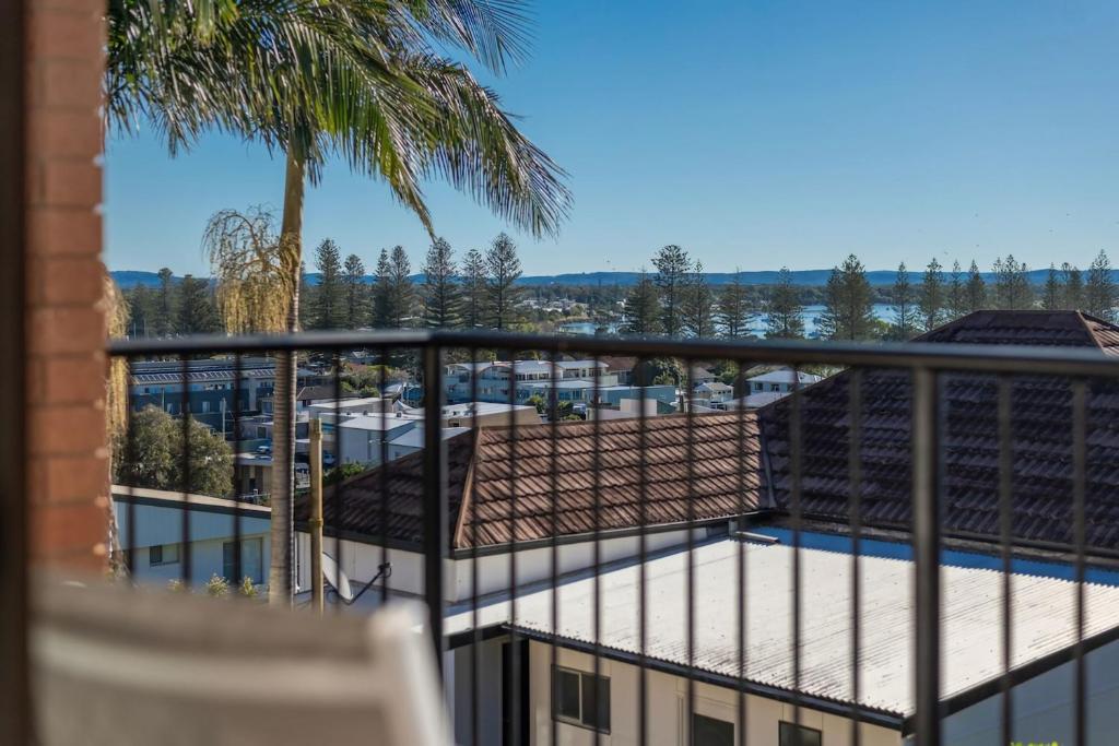 a balcony with a view of a building and a pool at Elsewhere 3- Town Location - Stone Real Estate Yamba in Yamba