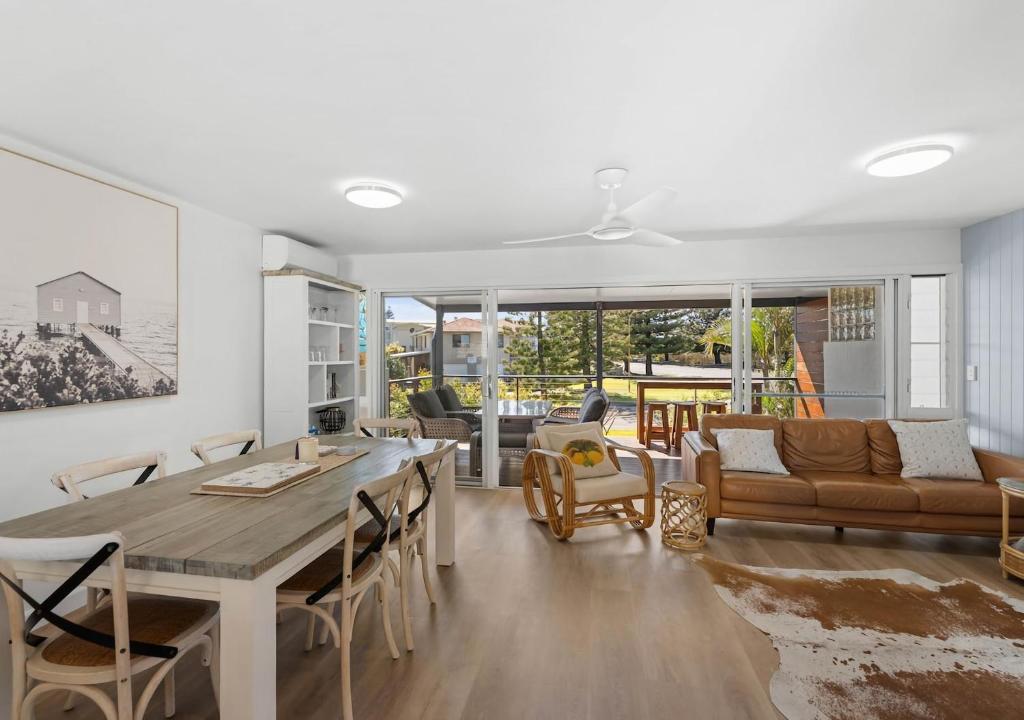 a kitchen and living room with a table and chairs at Pippi Sands - Pet Friendly - Stone Real Estate in Yamba