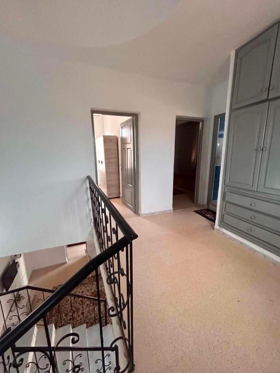 an empty room with a staircase and a door at djerba palm house in Mezraya