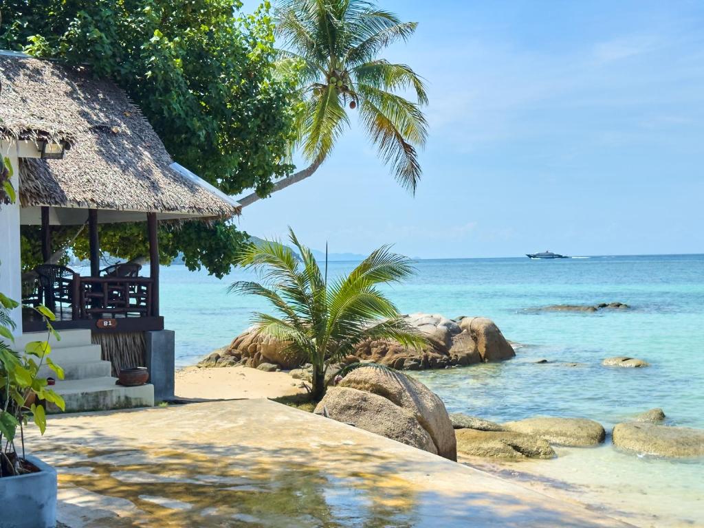 a beach with a hut and the ocean at Ocean Vibes Resort in Thong Sala
