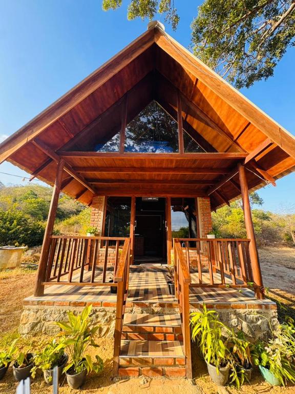 a house with a large wooden porch and a staircase at Wild Roots Cabana Arugambay in Arugam Bay