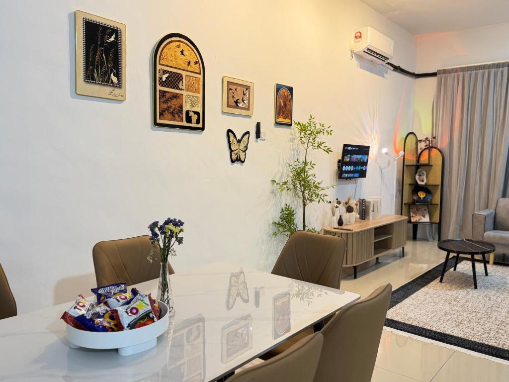 a dining room with a white table and chairs at 4B 3R Cozy Spacious Near Dewan Millenium Fully Aircond in Kepala Batas