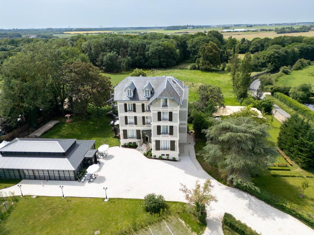 an aerial view of a large house with a driveway at Villa Edmond Hôtel & Spa - Maison Blanche Bièvres in Bièvres