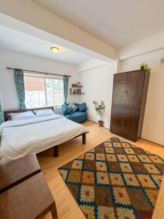 a bedroom with a bed and a rug at Studio By The Garden in Jawlakhel