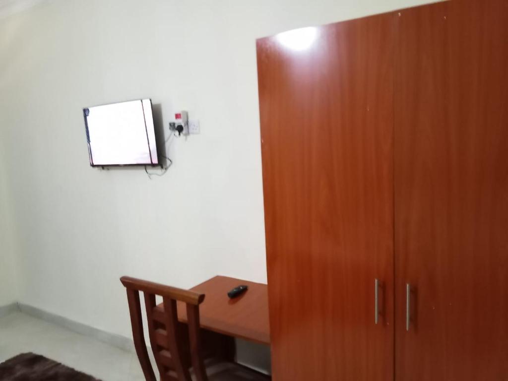 ein Zimmer mit einem Holzschrank und einem Schreibtisch in der Unterkunft Luanda Road View Hotel in Luanda