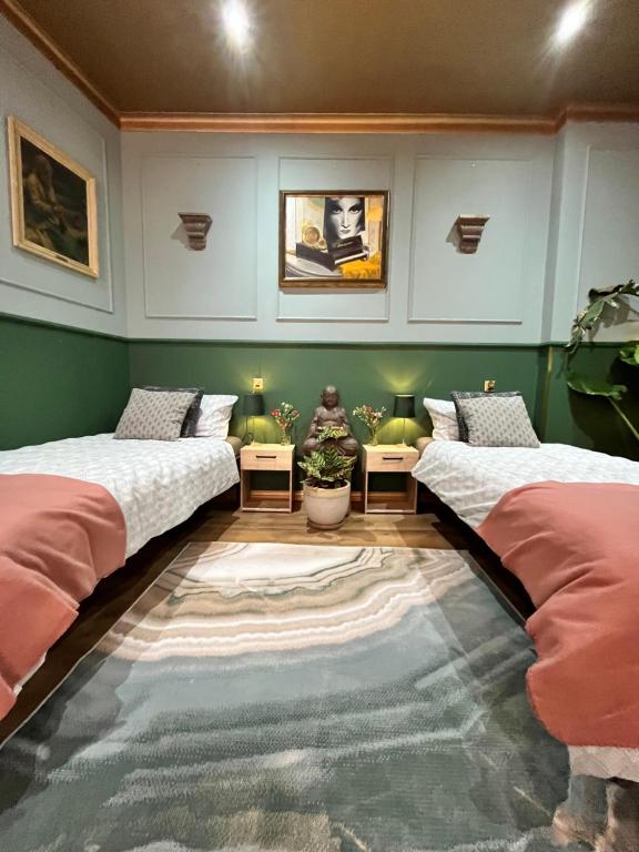 two beds in a room with green walls at Apartamenty Traugutta 47 in Radom