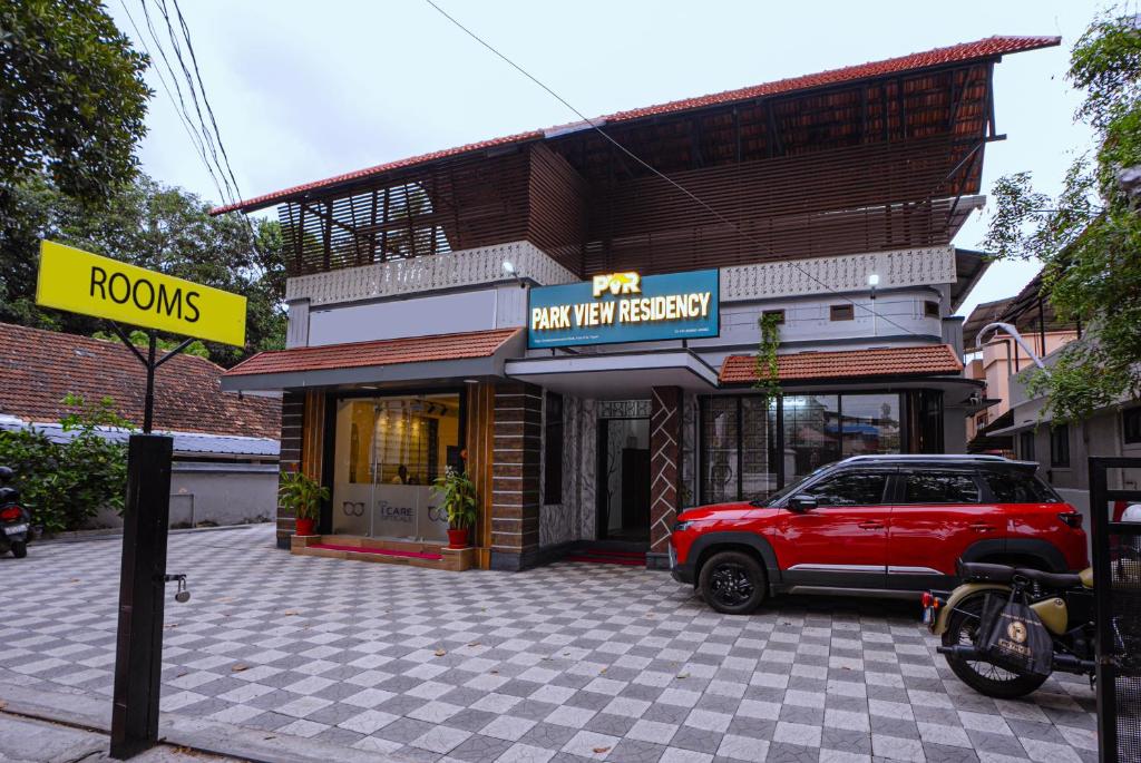 a red suv parked in front of a building at Park View Residency - Guest House Near Sree Padmanabhaswamy Temple in Trivandrum