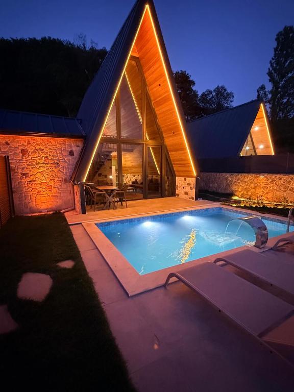 a swimming pool in front of a house at night at paşa barbun in Bartın