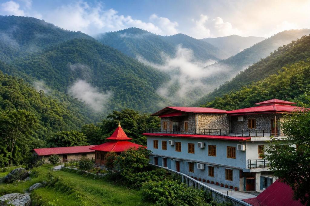 a building on a hill with mountains in the background at The Ushmaya Lifestyle Wellness Resort Near Rishikesh in Haridwār