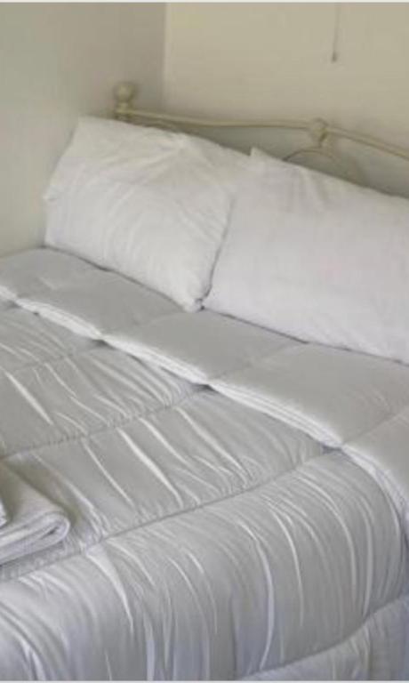a white bed with white sheets and pillows at Kinsale centre in Kinsale