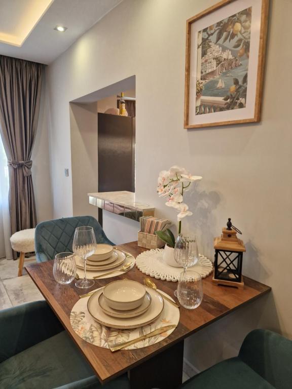 a dining room table with plates and glasses on it at Miradi Art Apartment in Stara Zagora