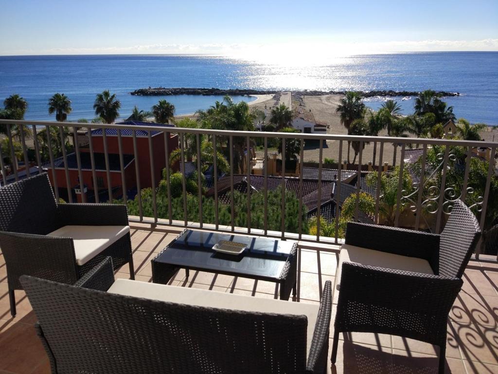 Un balcón con sillas, una mesa y el océano en The Terrace of Puerto Banus Beach, en Marbella
