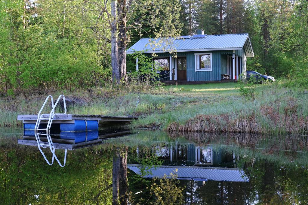 a cabin on a lake with a boat in the water at ILO103 in Huhus