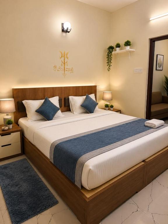 a bedroom with a large bed with blue pillows at Ferro Livingz in Kumbalgod