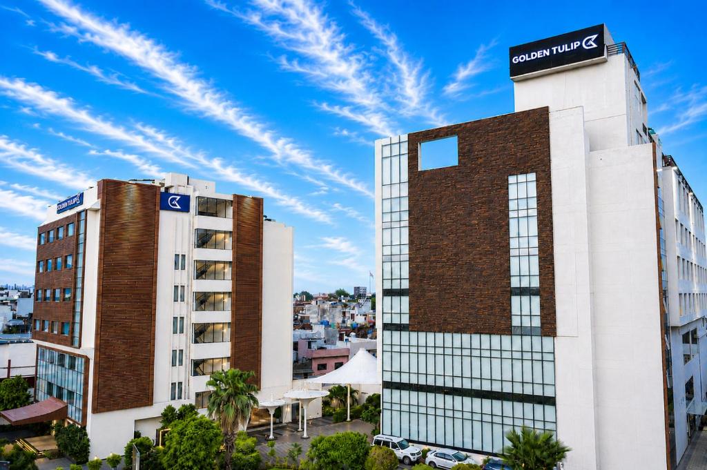 a building with a sign on top of it at Golden Tulip Lucknow in Lucknow