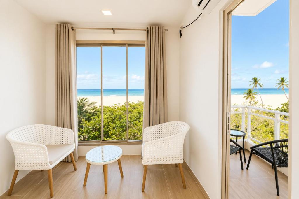 a room with chairs and a view of the ocean at Avyanna Gulhi Beach Hotel in Gulhi