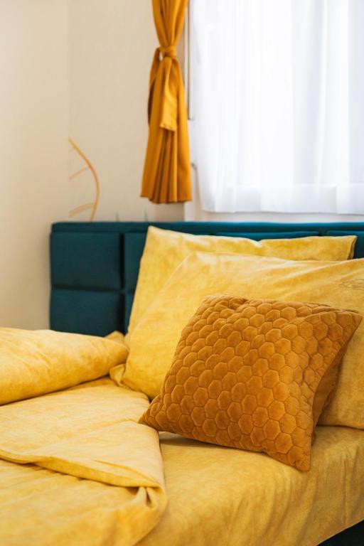 a yellow bed with a blue headboard and a pillow at Dream Apartment in Vrnjačka Banja