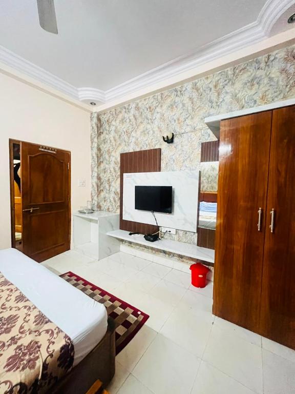 a bedroom with a bed and a flat screen tv at Hotel Natraj Palace in Seonī