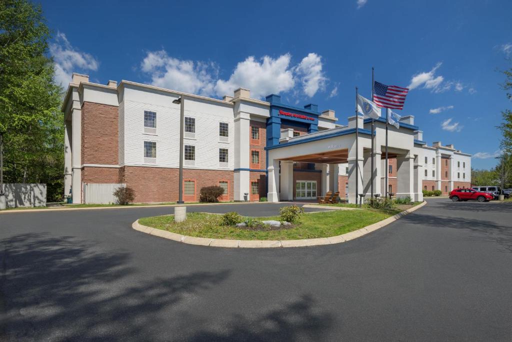 a building with an american flag in front of it at Hampton Inn & Suites Berkshires-Lenox in Lenox