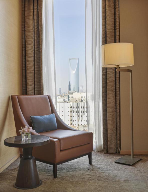 a living room with a chair and a table and a window at Hyatt Regency Riyadh Olaya in Riyadh