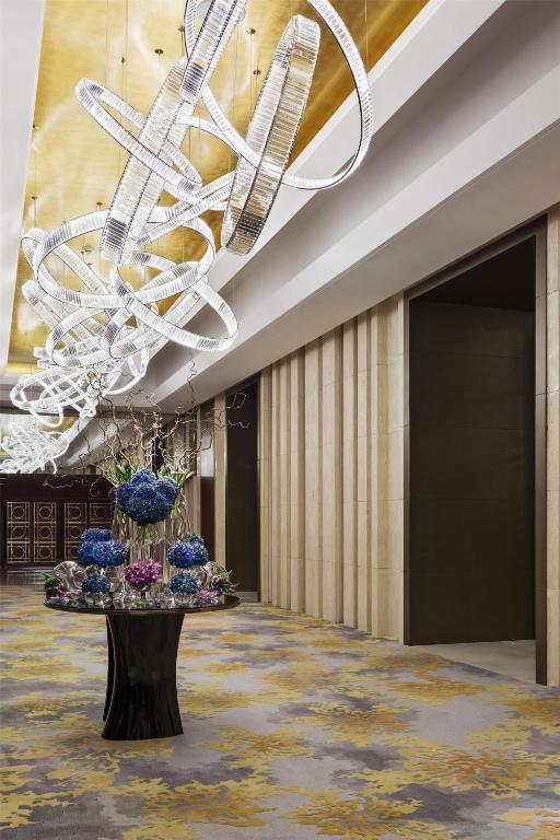 a lobby with a chandelier and a table with flowers at Hyatt Regency Riyadh Olaya in Riyadh