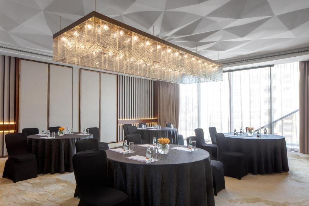 a conference room with tables and chairs and a chandelier at Hyatt Regency Riyadh Olaya in Riyadh
