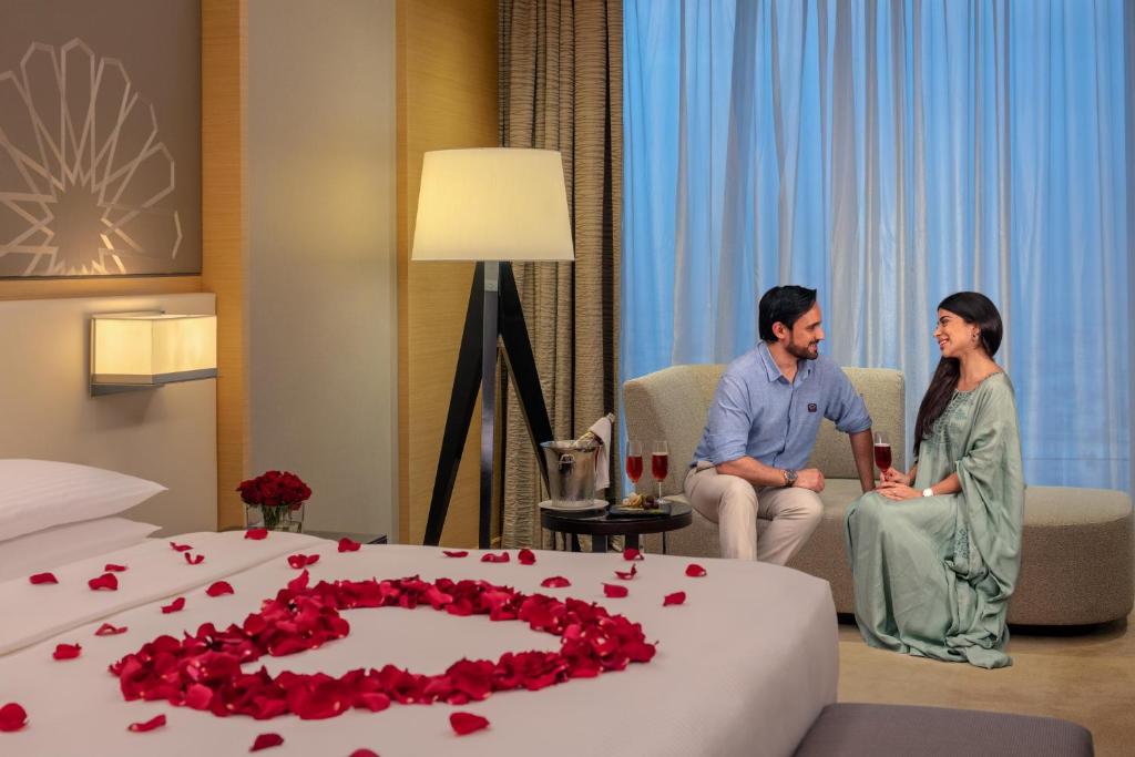 a man and a woman sitting in a hotel room with a cake at Hyatt Regency Riyadh Olaya in Riyadh