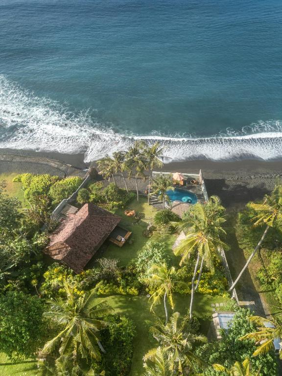 an aerial view of a resort with palm trees and the ocean at Secret Moon Beach House in Jasri