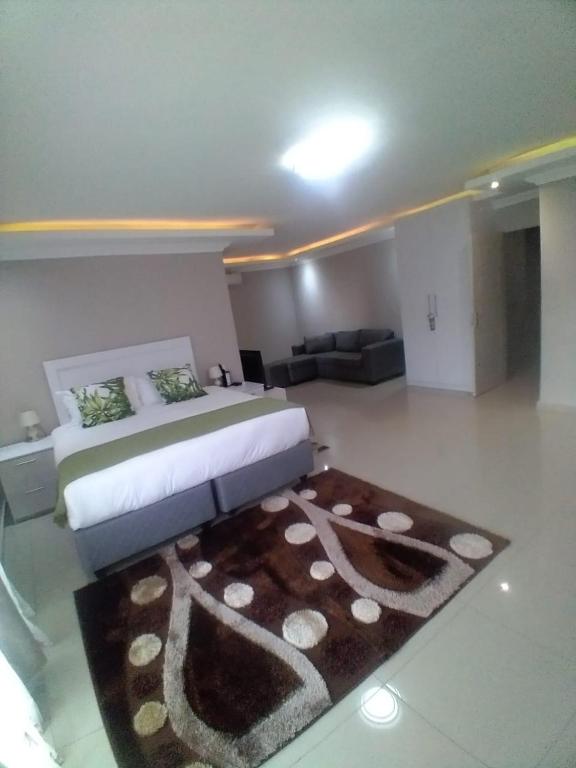 a bedroom with a large bed and a rug at Bosago lodge and Spa in Burgersfort